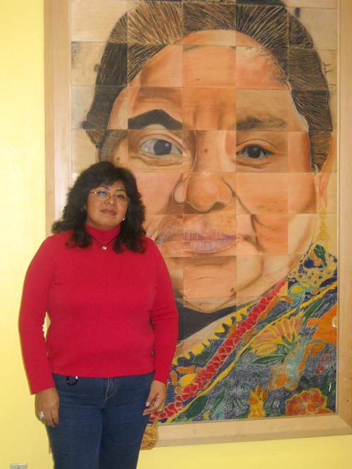 Araceli Alvarez, in front of 'Crossing Borders' mural, a collaborative art project of El Centro Hispano and See Saw Studios. Photo by Cara Oxendine